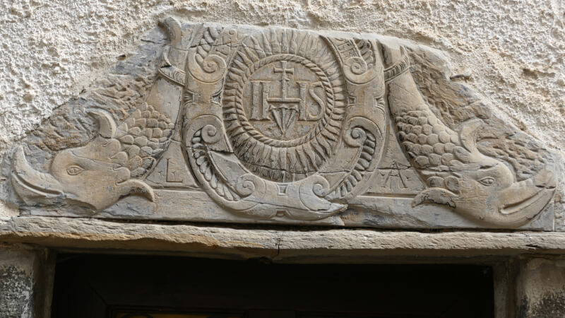 Architrave in pietra scolpita con delfini e Chrismon del portale della casa di Lazzaro Acquarone, Lucinasco